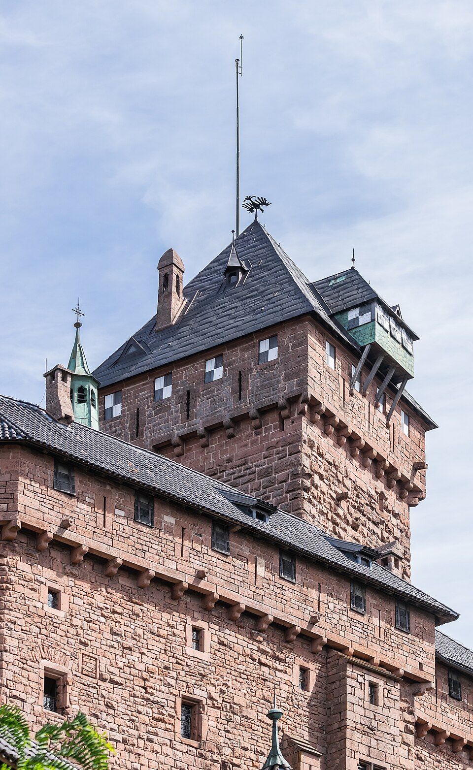 Les tours et les murs de grès rose du château du Haut-Koenigsbourg sur son piton boisé